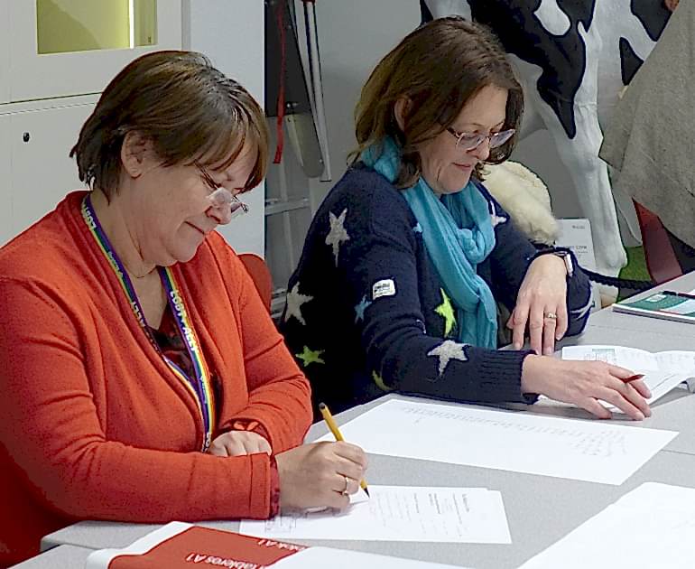 Two women seated at a table in the Learning Studio during one of our forums.
