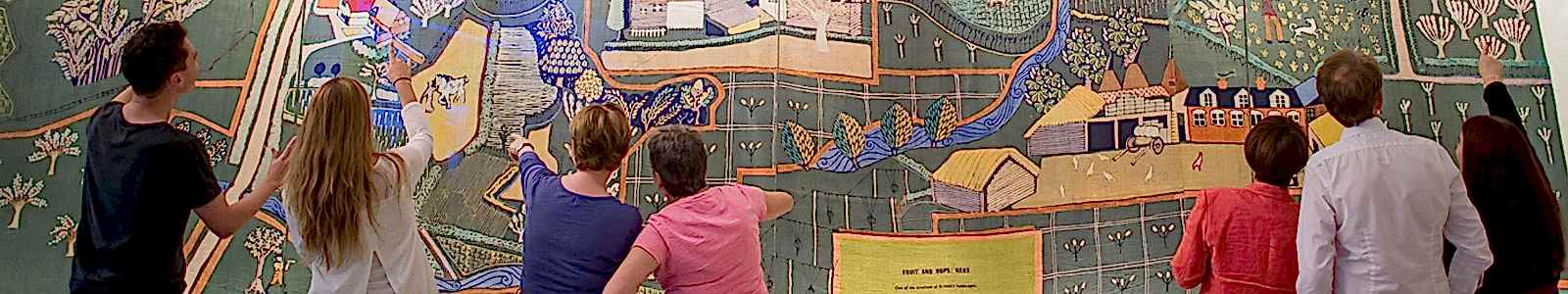 People on a group visit to the MERL looking at the O'Connell wall-hanging