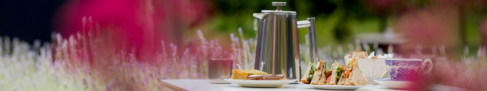 Table in the MERL garden with coffee pot, sandwich and cake