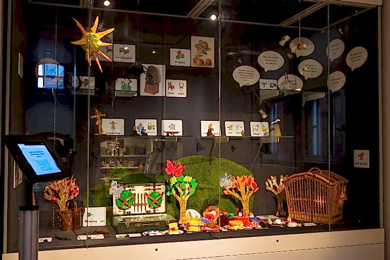 Display case containing museum objects, crafted picnic items and makaton symbols