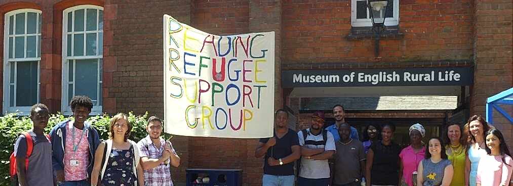 A group of people stand outside the Museum of English Rural Life holding a banner that reads 