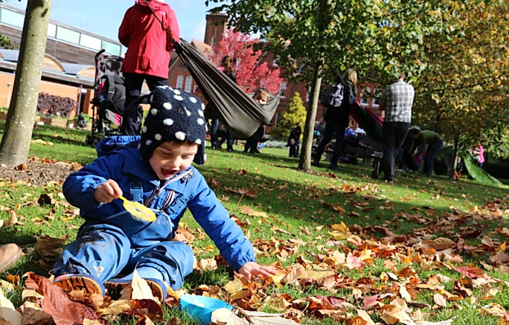 A child plays with leaves in our garden.