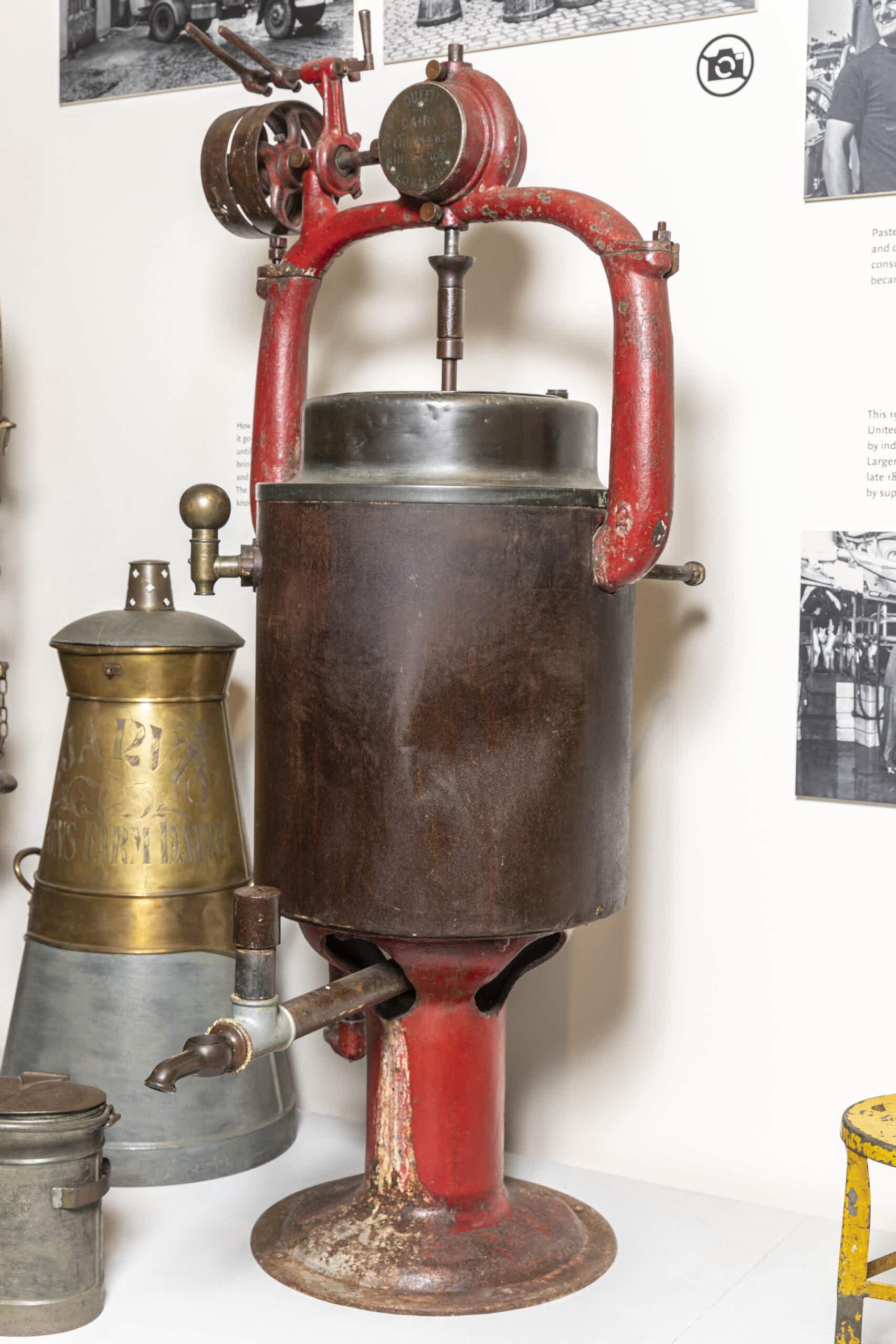 metal a dented metal cylinder with red pipes on display in museum gallery