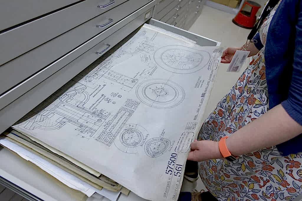 An archivist looks at a drawing within a drawer